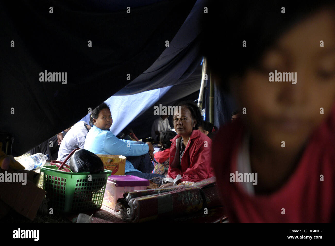 Jul 20, 2006; Ciamis, West Java, INDONESIA; Residents of Babakan village which was affected by Monday's tsunami sit in a tent at an IDP camp at Sukaurip in the hills above Pangandaran. A tsunami hit the coast of the Indonesian island of Java killing more than 550 people, leaving over 600 injured. Over 38,000 others have been displaced by the disaster. An earthquake around 240km ben Stock Photo