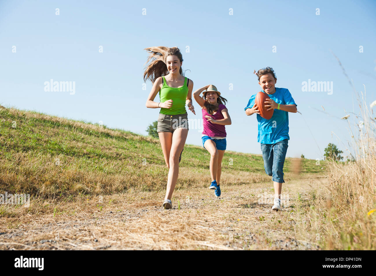 Girls running along pathway in field, Germany Stock Photo