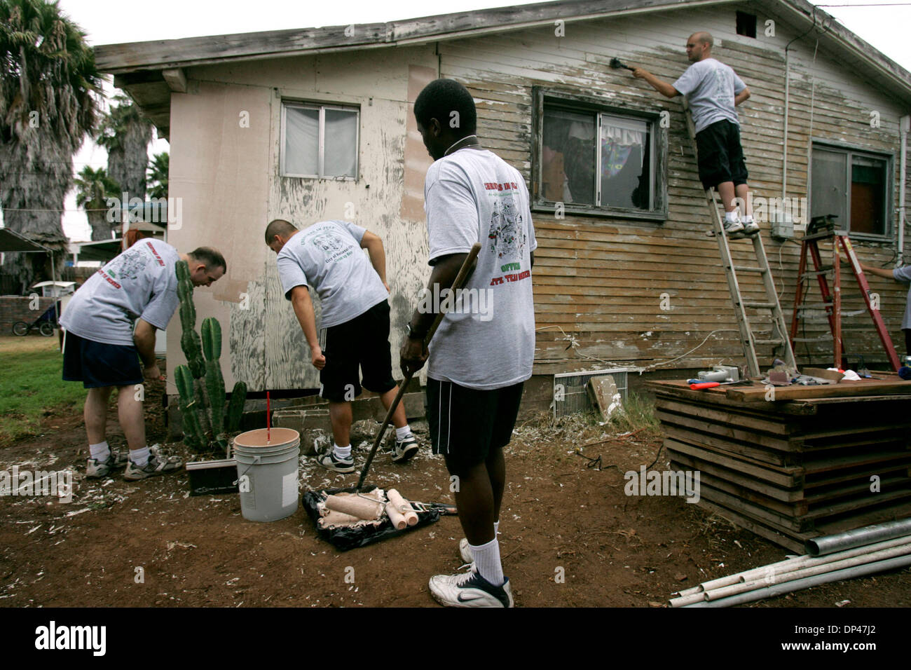 Jul 29, 2006; National City, CA, USA; Navy Fleet Anti-Submarine Warfare volunteers GREG BINGMAN, left, and DAVE CURRIER, check for spiders as SHAWN KING, center, and JAY AU, right, prepare a National City home for painting as part of Christmas in July. The organization is a non-profit that repairs and rehabilitates old homes.  Mandatory Credit: Photo by Laura Embry/SDU-T/ZUMA Press Stock Photo