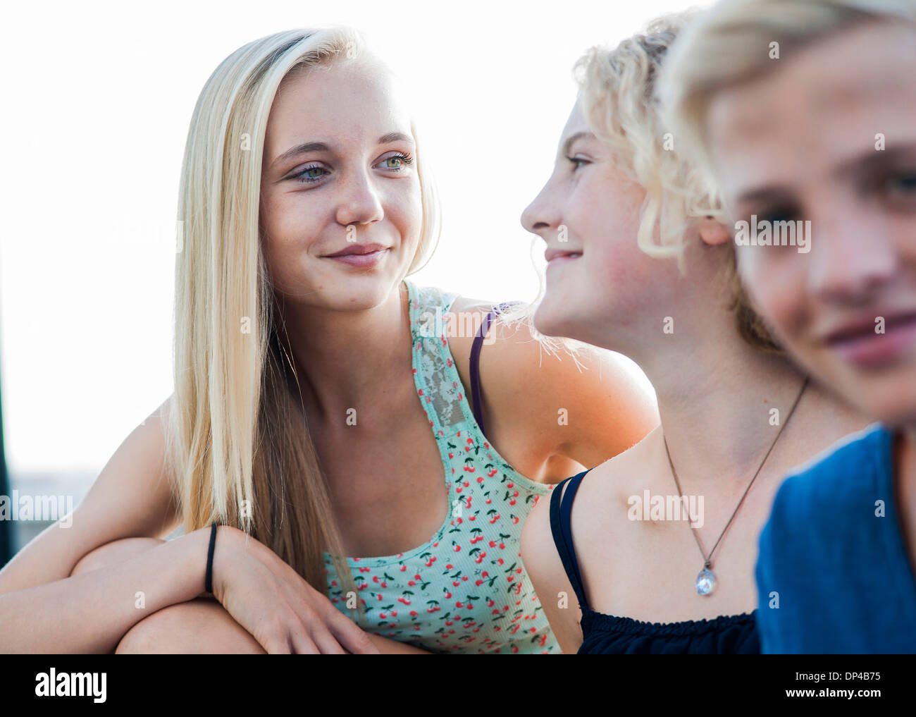 Close-up portrait of teenage girls and boy sitting outdoors, Germany Stock Photo