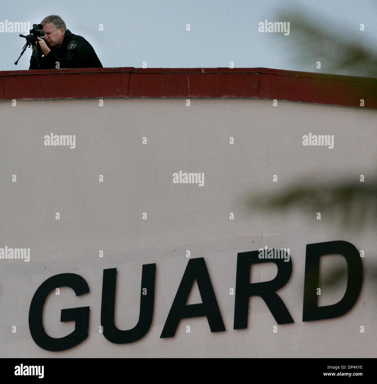 Aug 17, 2006; San Diego, CA, USA; A San Diego Police SWAT team member watches the activity below from a hanger at the San Diego Coast Guard Station surrounding the transfer from a Coast Guard vessel of members of the Arellano-Felix drug cartel to waiting DEA SUVÕs. The suspects, as many as 11 were arrested in international waters off the coast of Baja California on Monday August 14 Stock Photo
