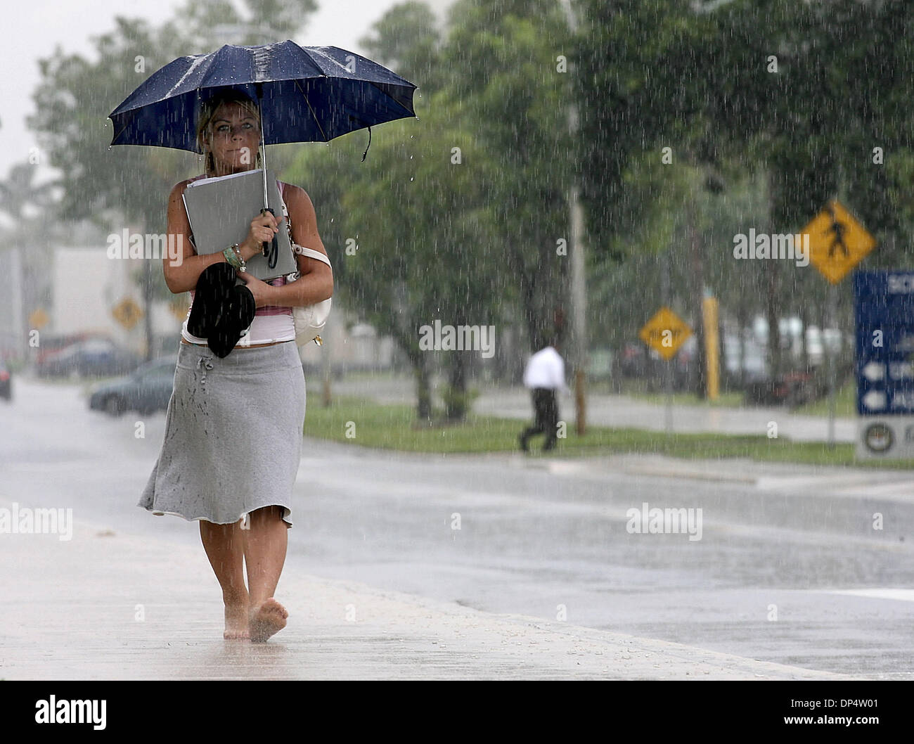 Aug 24, 2006; Boca Raton, FL, USA; Florida Atlantic University sophomore Jennifer Merlin carries her sandals as she walks barefoot to math class, Thursday afternoon as thunderstorms drenched the campus. She said she was lucky to pass her dorm along the way where she picked up her umbrella.  Mandatory Credit: Photo by Bob Shanley/Palm Beach Post/ZUMA Press. (©) Copyright 2006 by Pal Stock Photo