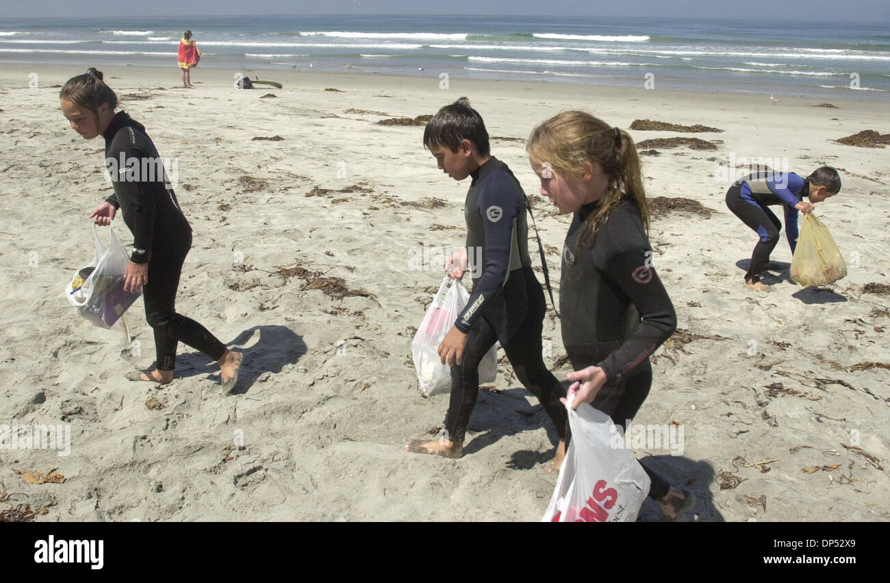 (Published 07/13/2003, N-15, UTS1747907) Members of the Eli Howard Surf camp (from left) Katie Coats, 9, Mathew Dominguez, 10, Kelsey Miller, 10, Jeffrey Horine, 10, clean up the beach between surf sessions on Thursday at South Carlsbad State Beach. UT photo by Eduardo Contreras Stock Photo