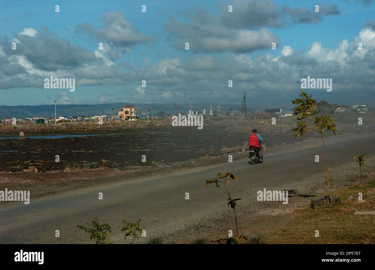 Sep 06, 2006; Banda Aceh, INDONESIA; An Acehnese rides a motorcycles crossing the area where worst hit by Indian ocean tsunami at Meuraxa. Sign of routine life have returned to the people of Aceh after Indian ocean tsunami hit the region on December 26, 2004 where an estimated 167.000 killed and some 500.000 homeless. Indonesia, by far the worst hit, more than 60,000 people are sti Stock Photo