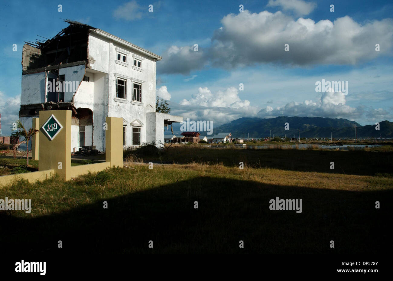 Sep 06, 2006; Banda Aceh, INDONESIA; The ruin of Meuraxa hospital stands close to mass burial in the area that worst hit by Indian ocean tsunami. Sign of routine life have returned to the people of Aceh after Indian ocean tsunami hit the region on December 26, 2004 where an estimated 167.000 killed and some 500.000 homeless. Indonesia, by far the worst hit, more than 60,000 people  Stock Photo