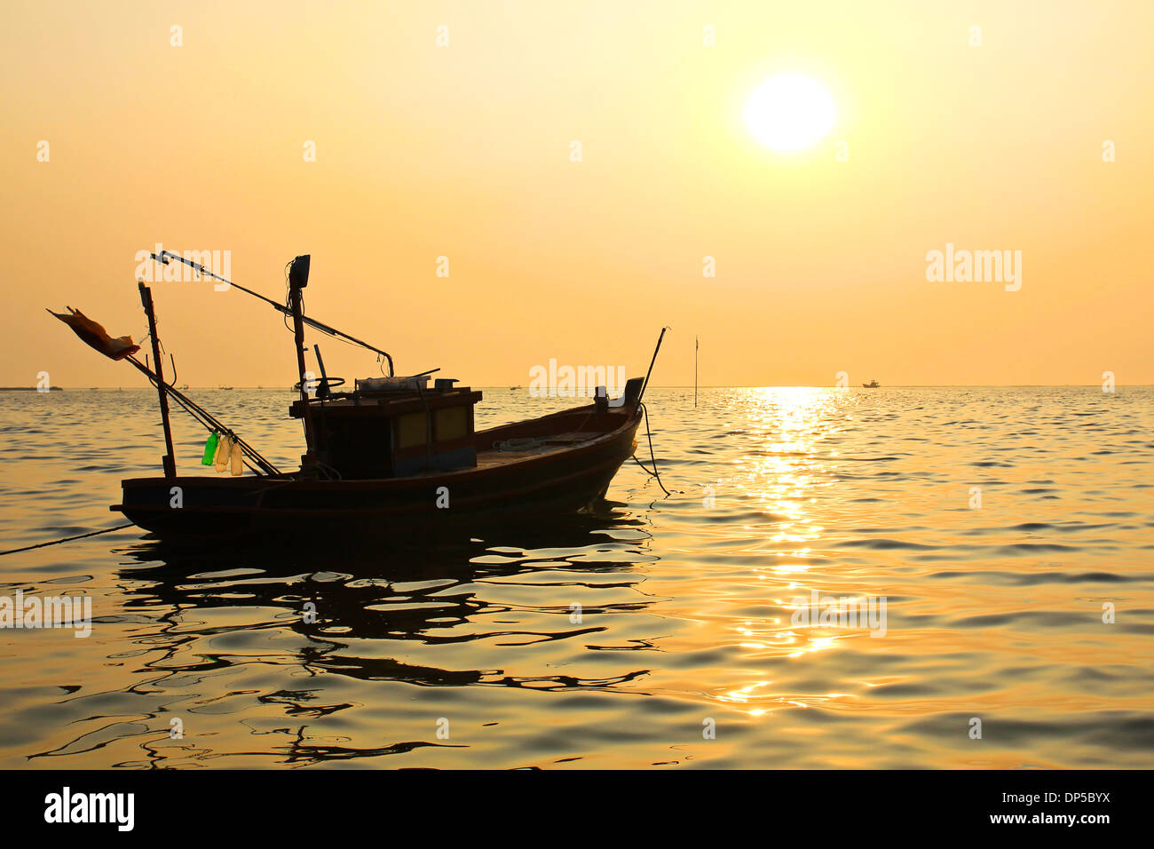 Silhouette of fishing boat at sunset Stock Photo