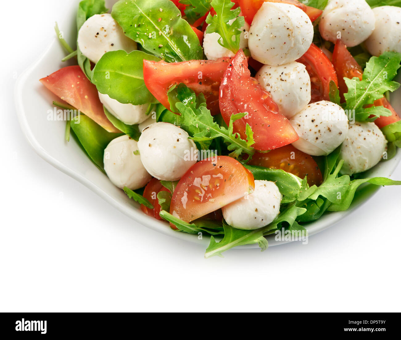 Fresh and healthy salad with tomato mozzarella and lettuce served in a white bowl with a soft shadow Stock Photo