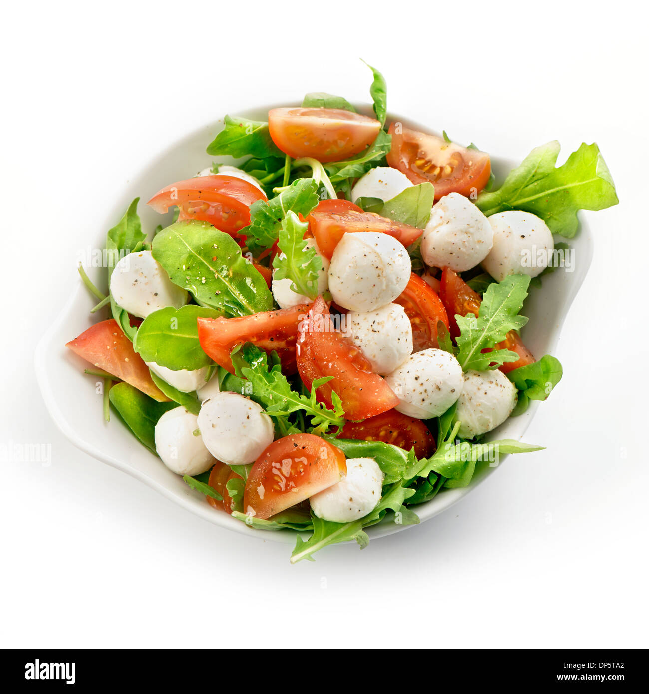Fresh and healthy salad with tomato mozzarella and lettuce served in a white bowl with a soft shadow Stock Photo