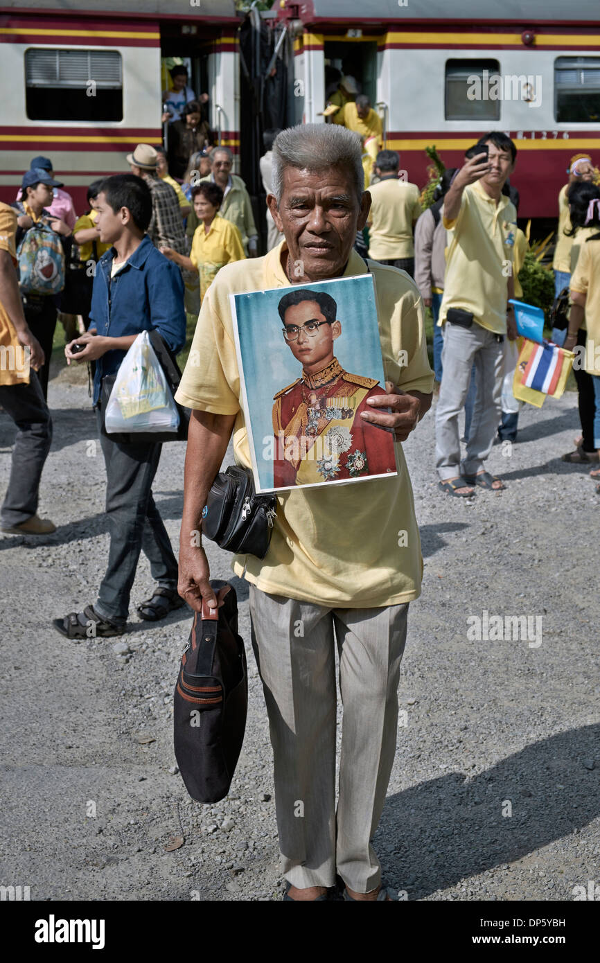 Thailand Yellow shirt supporters and elderly man alighting from the train to pay respects to the Thailand King on his birthday. Stock Photo