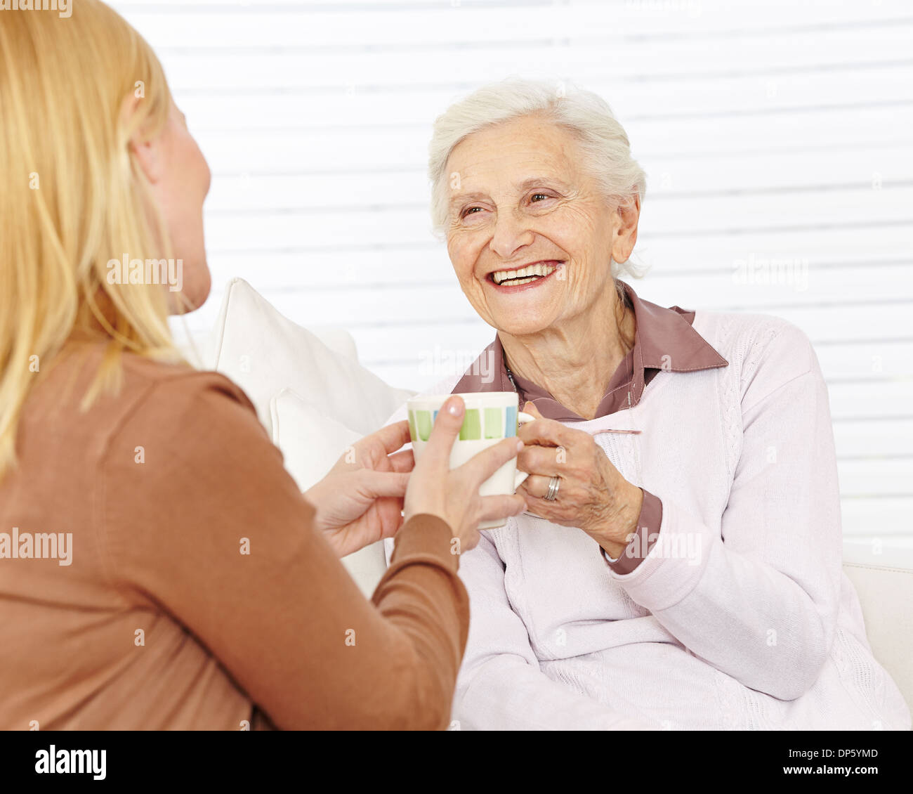 Family with senior woman drinking coffee in a retirement home Stock Photo