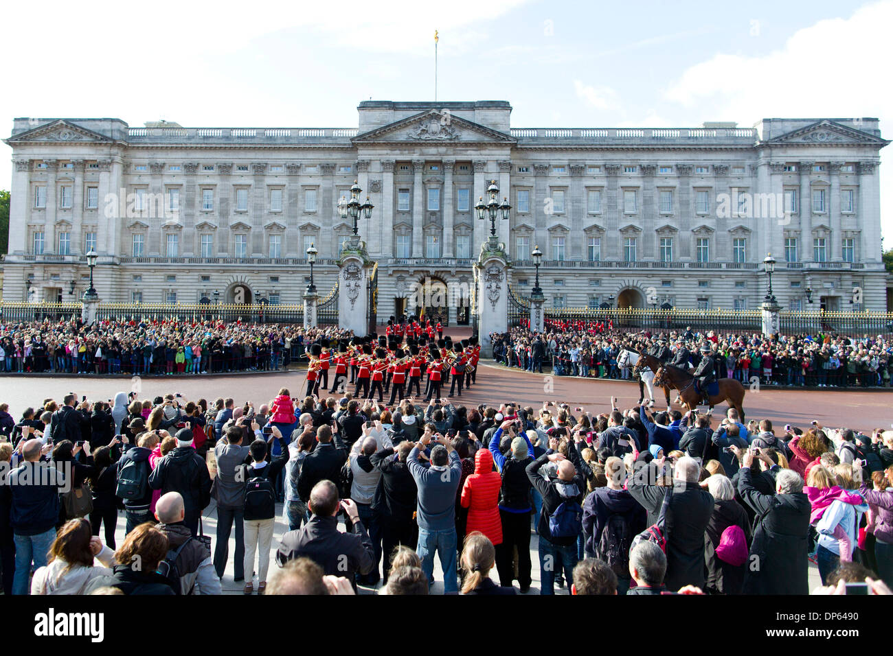 Crowds of tourists watch The Changing of the Guard outside Buckingham Palace in London. Stock Photo