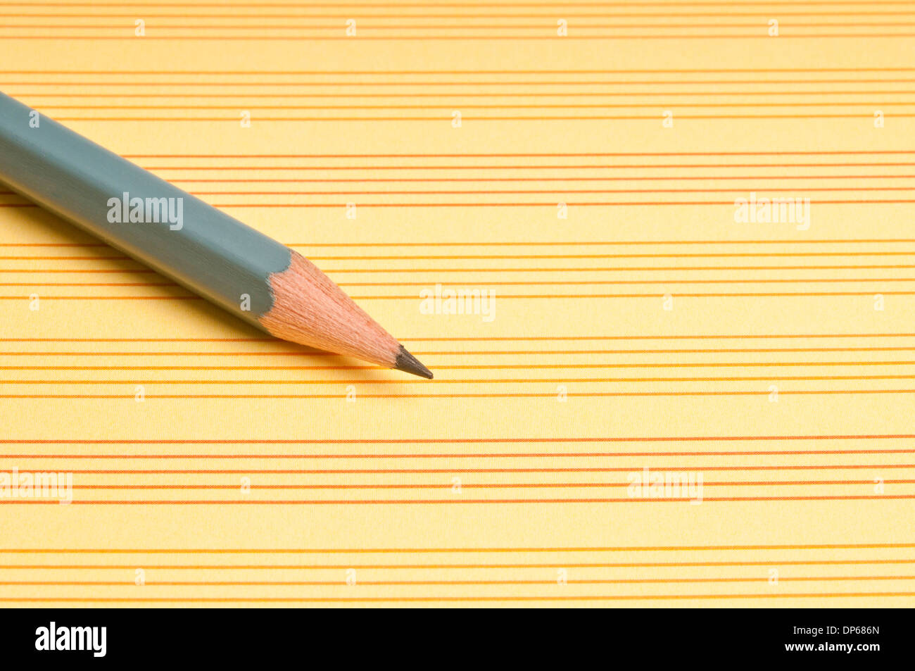 pencil on a yellow paper with lines Stock Photo