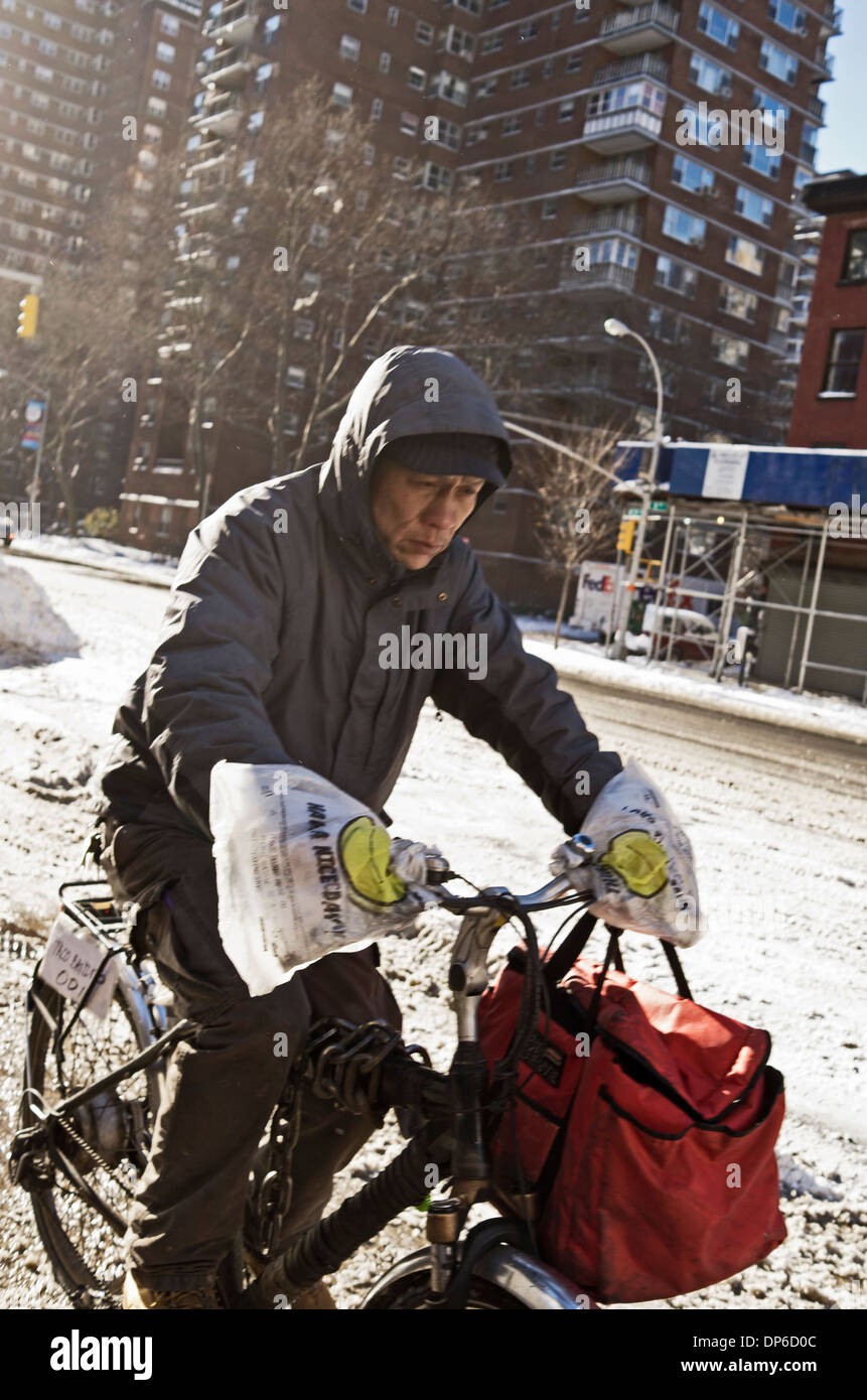 Cyclist in New York snow using plastic carrier bags for gloves. Stock Photo