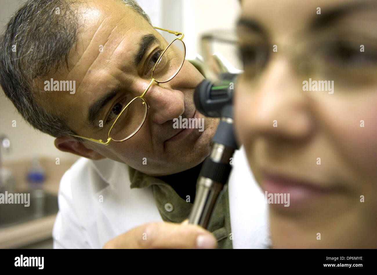 SECONDARY COVER /// Dr. Douglas Everett DeSalles, left, examines patient  Erin MCIKinney Sunday, December 31, 2006 at a local medical office. When  not treating patients, DeSalles, as Doug Everette, hosts Radio Parallax,