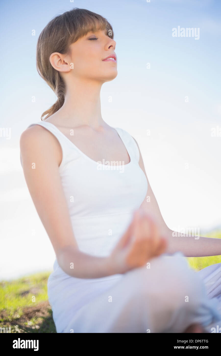 Peaceful young woman relaxing in yoga position Stock Photo