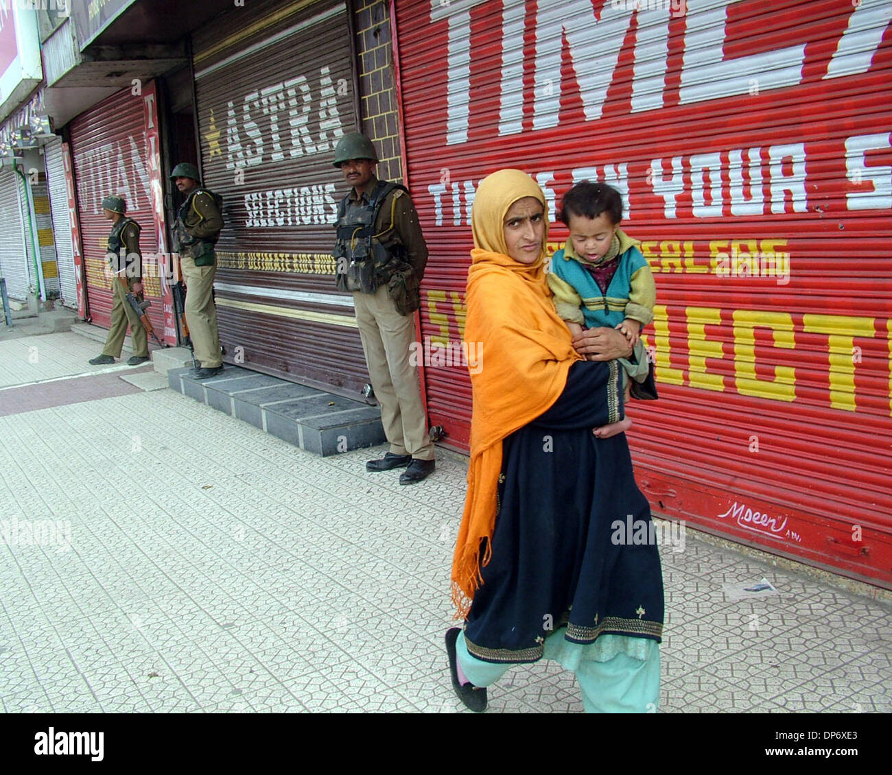 Oct 27, 2006; Srinagar, Kashmir, INDIA; A woman walks past soldiers in Srinagar as seperatists of Srinagar call for a general strike to mark India's Infantry Day. On Oct 27th,1947 the first batch of Indian army came to Kashmir to fight against Pakistan soldiers. Mandatory Credit: Photo by Altaf Zargar/ZUMA Press. (©) Copyright 2006 by Altaf Zargar Stock Photo