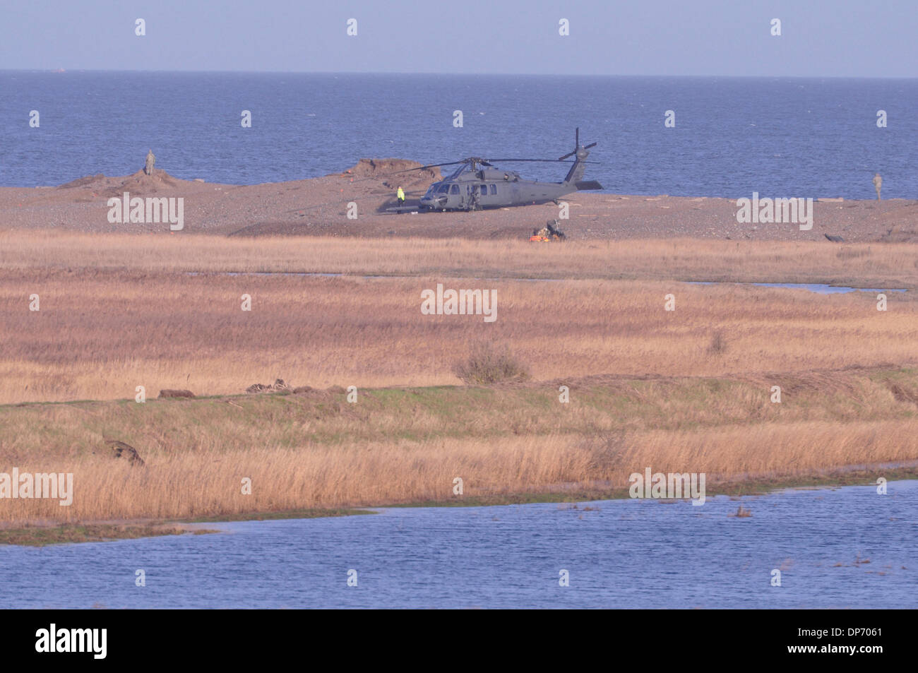Cley-next-the Sea, Norfolk, UK. 8th Jan, 2014. Pave Hawk crashed 8pm 7th January 2014 on shingle bank at at Cley-next-the Sea Norfolk UK. Crew of four dead. An intact accompanying aircraft sits on the shingle with wreckage of the lost aircraft just visible this side of it. Credit:  John Worrall/Alamy Live News Stock Photo