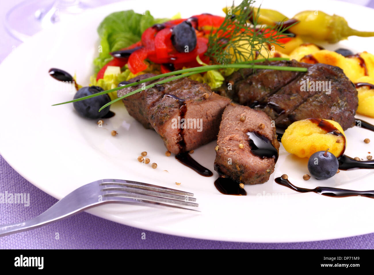 Lamb steak with potato, vegetable and black sauce, close up Stock Photo