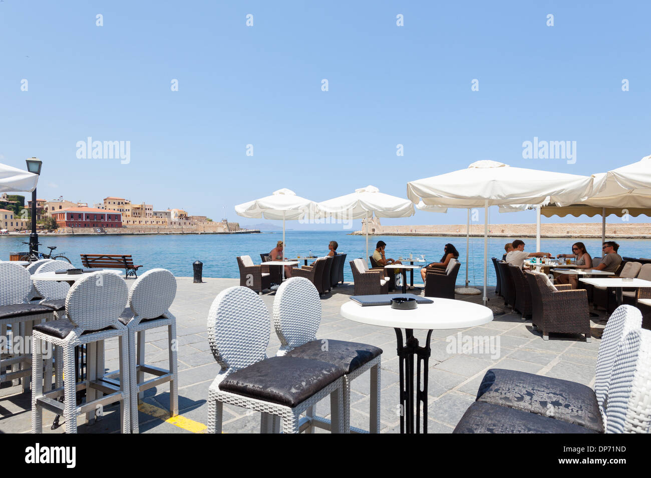 People enjoying in a restaurant cafe pub at the ancient Venetian harbor of Chania, Crete Island, Greece Stock Photo