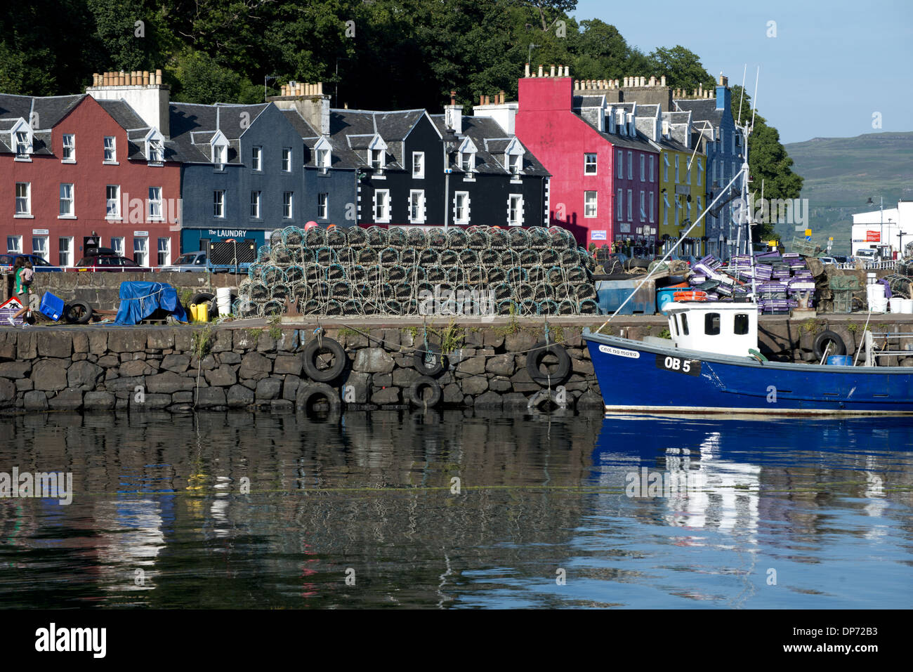 View of lobster pots and fishing boat at harbour of coastal town, Tobermory, Isle of Mull, Inner Hebrides, Scotland, July Stock Photo