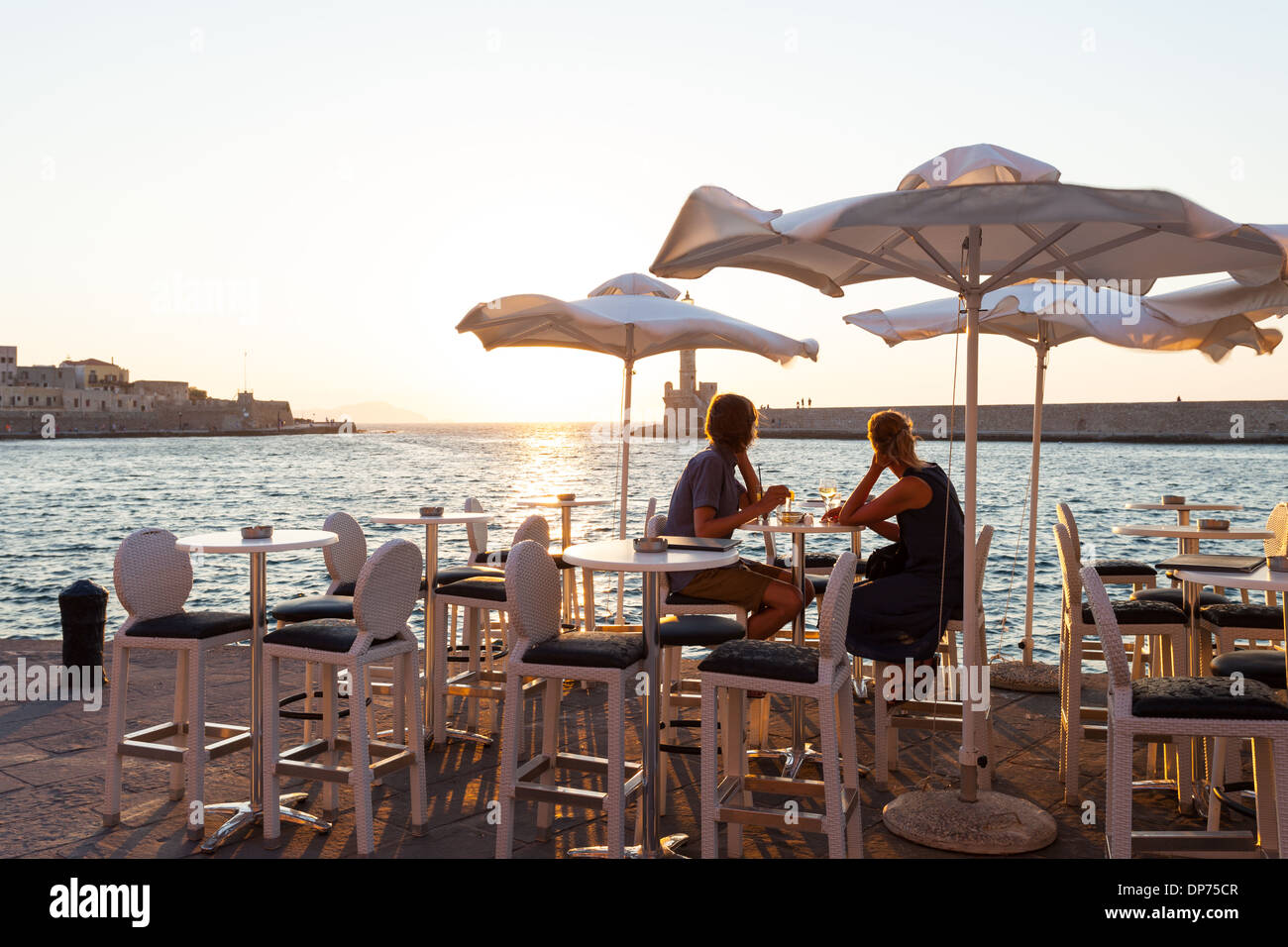 Having a drink in a pub in the Venetian harbor of Chania at sunset, Crete Island, Greece Stock Photo