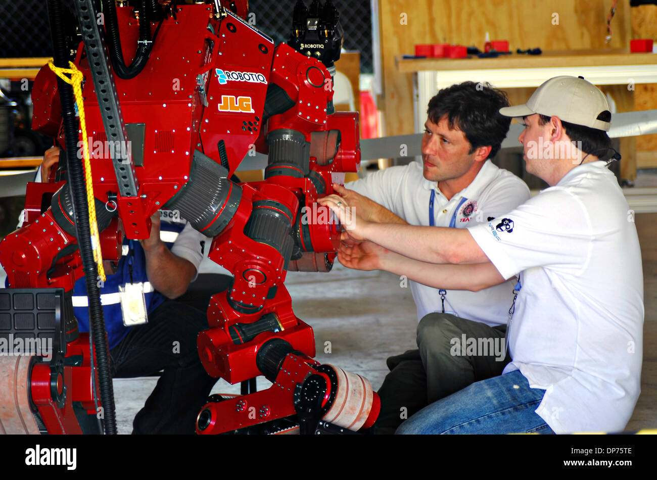 Technicians prepare the Robotiq 3-Finger Adaptive Robot Gripper robot during the DARPA Rescue Robot Showdown at Homestead Miami Speedway December 20, 2013 in Homestead, FL. The DARPA event is to challenge teams to design robots that will conduct humanitarian, disaster relief and related operations. Stock Photo