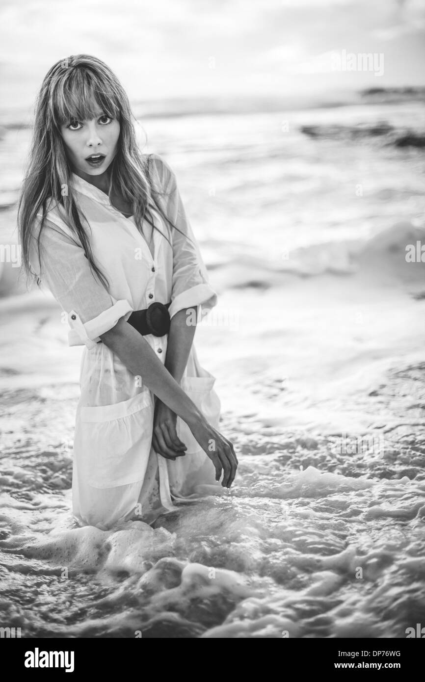 Beautiful model in shirt dress standing in the sea Stock Photo