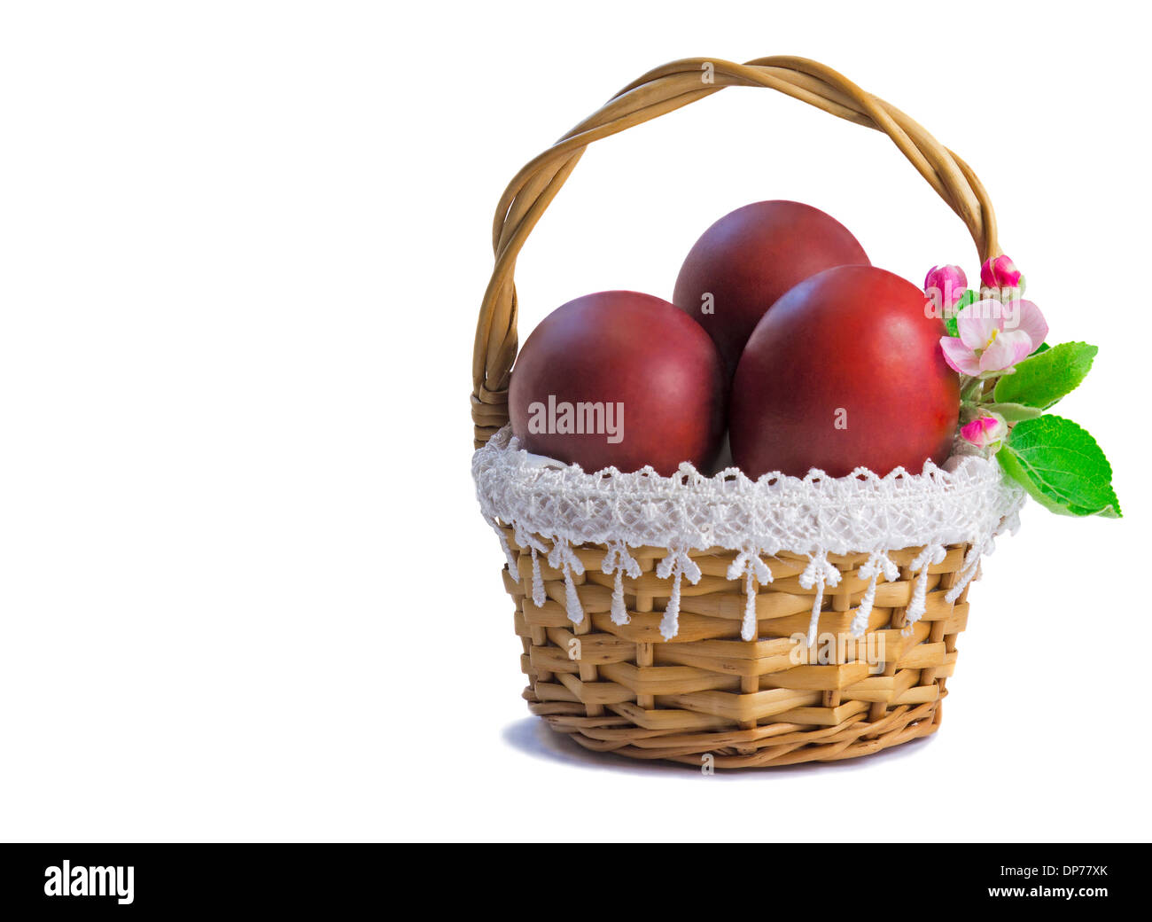 Three Easter eggs, painted in red, are beautifully decorated with wicker basket. Presented on a white background. Stock Photo