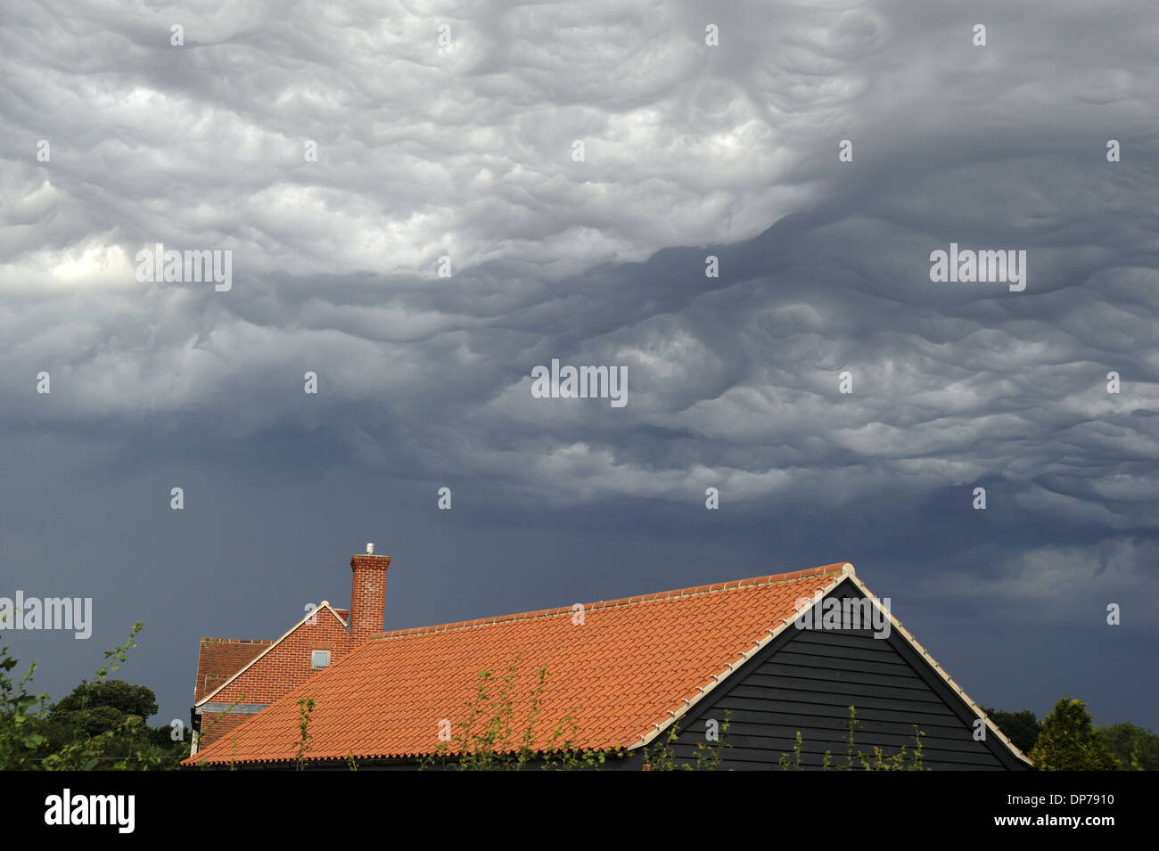 Asperatus clouds and stormclouds over rooftops, Bentley, Suffolk, England, August Stock Photo