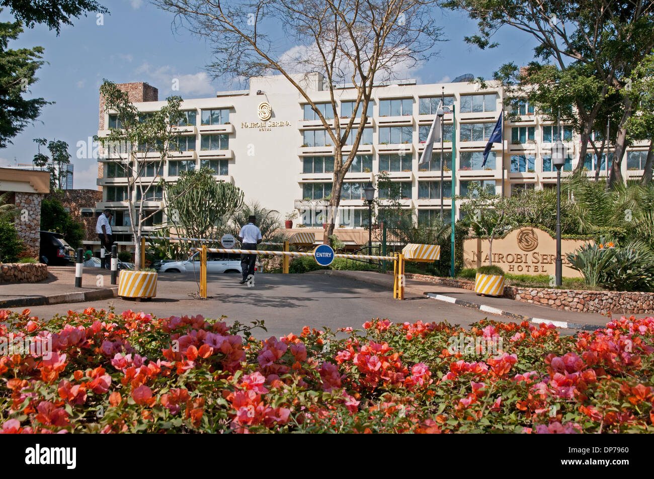 Exterior of Nairobi Serena Hotel Nairobi Kenya Africa showing double barriers at entrance to car park with bougainvillea flowers Stock Photo