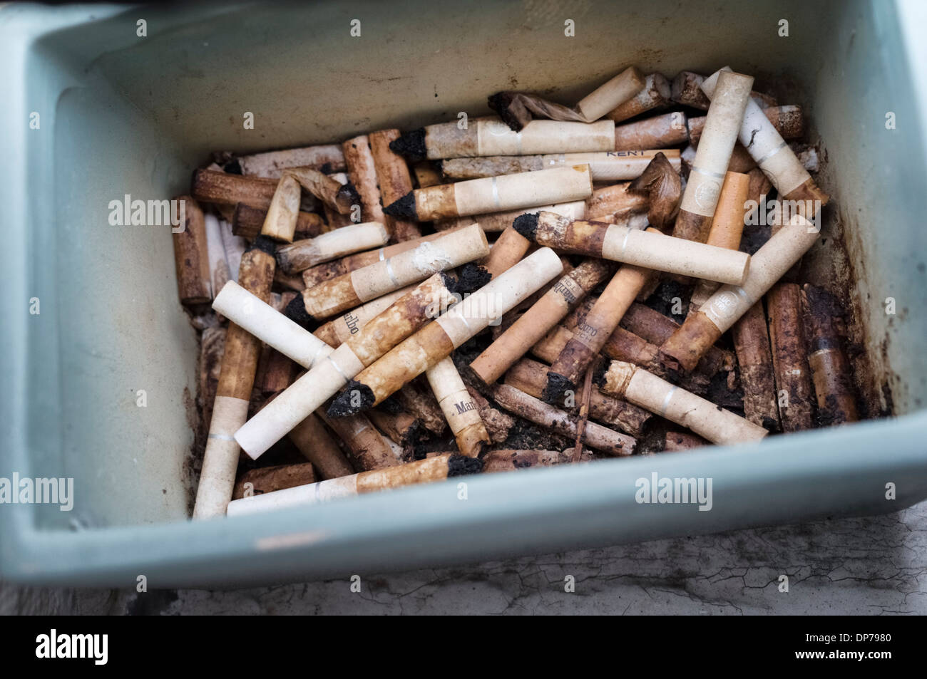smoking - cigarette butts in a dirty ashtray outdoors Stock Photo