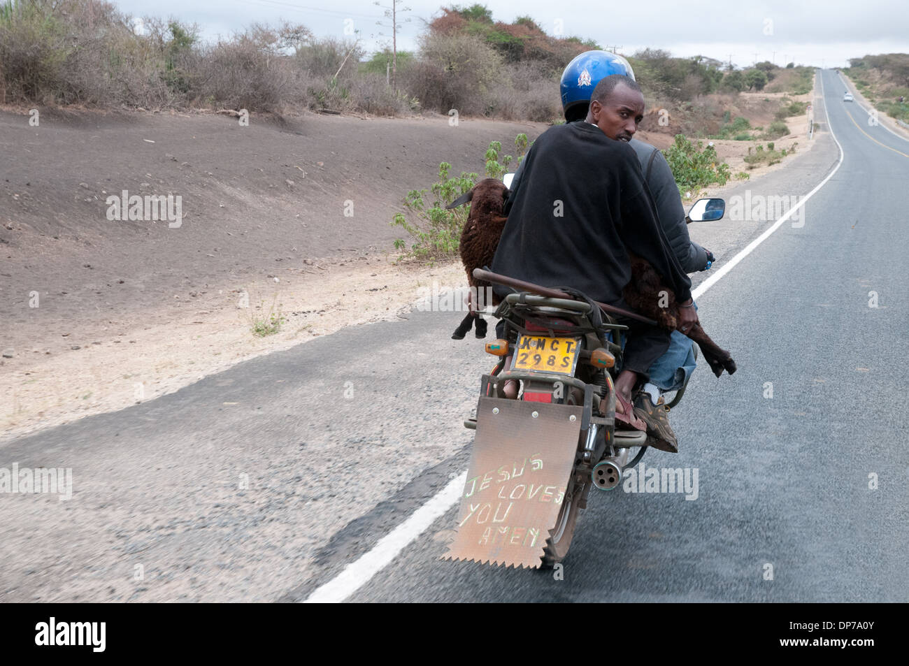 Motor Cycle Taxi with client carrying a goat on Nairobi Namanga road south of Kajiado Kenya Africa Stock Photo