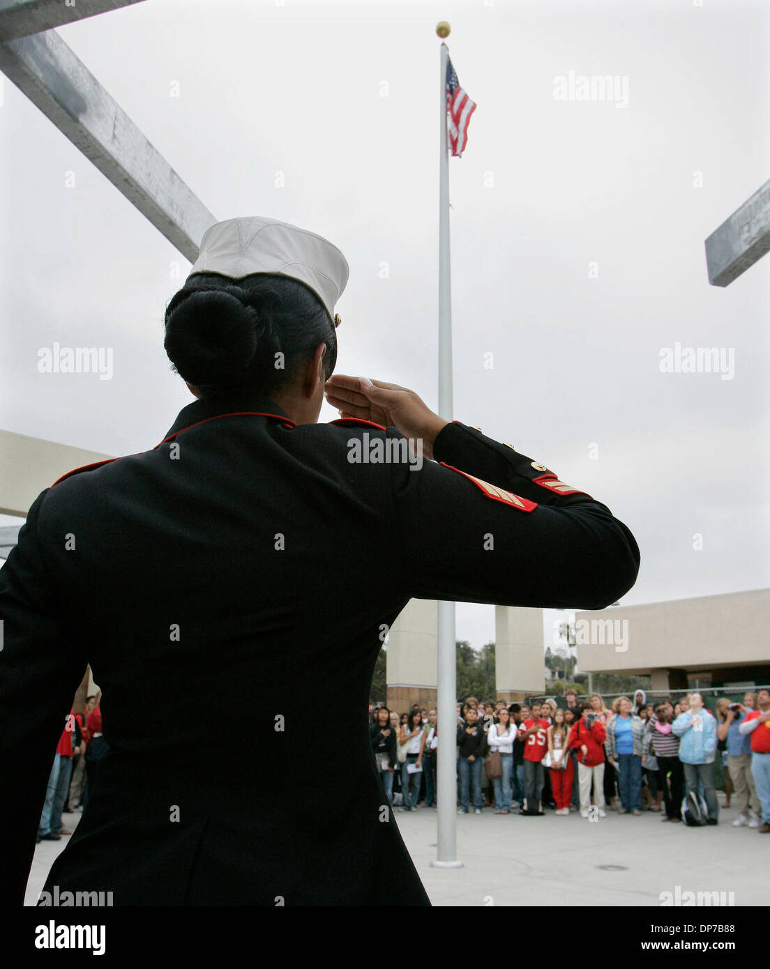 Nov 09, 2006; Rancho Penasquitos, CA, USA; Marine Sgt. VICTORIA ETIENNE salutes the flag which was flown over Camp Eggers in Kabul, Afghanistan on Sept. 11 of this year, then sent to Mt. Carmel High School teacher and coach Chris Vitous by Lt. Col. David Guzman who was an assistant coach at the school before he was deployed in June. The flag was raised in front of the recently remo Stock Photo