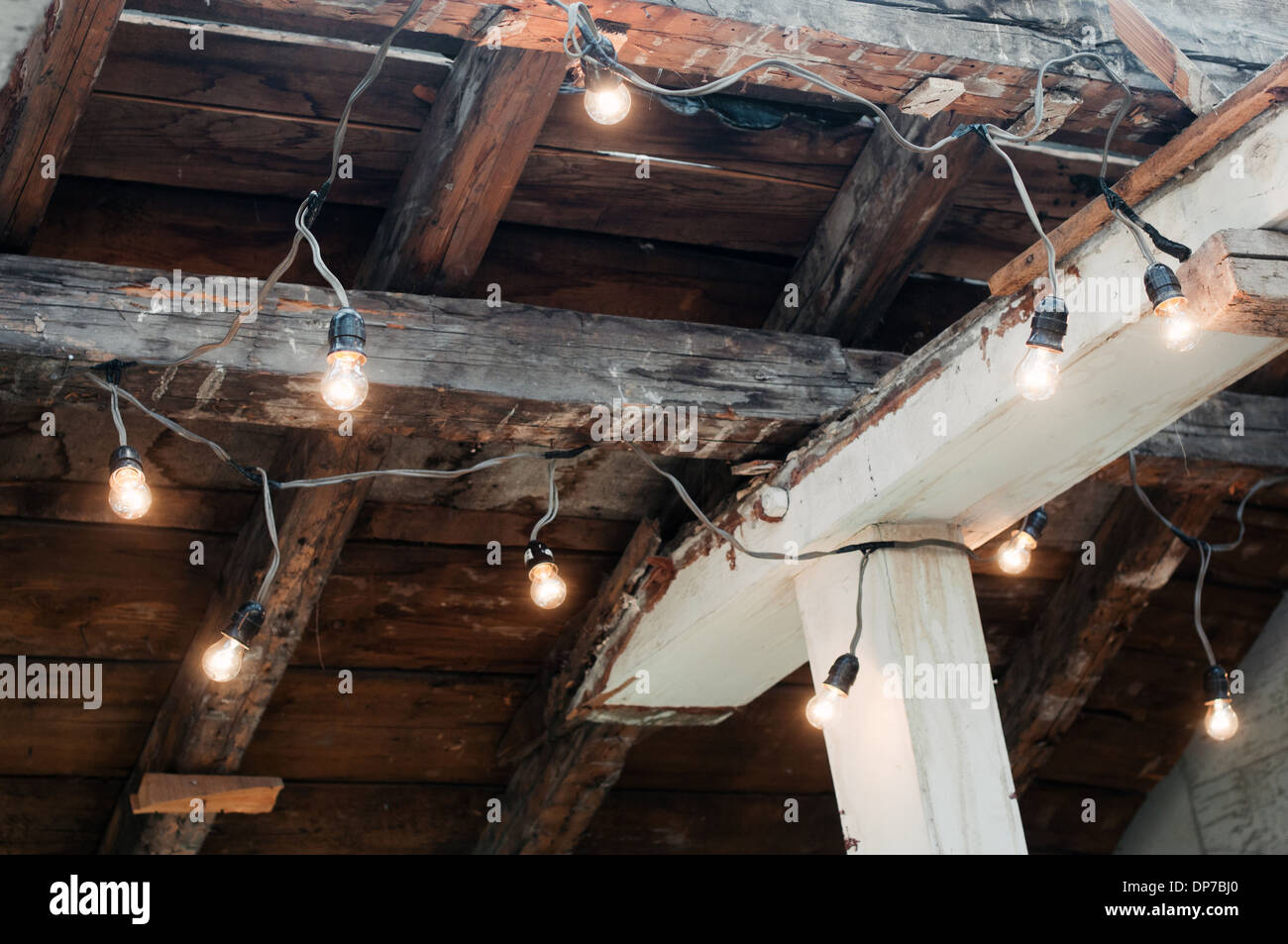 Electrically illuminated light bulbs hanging on old wooden ceiling Stock Photo