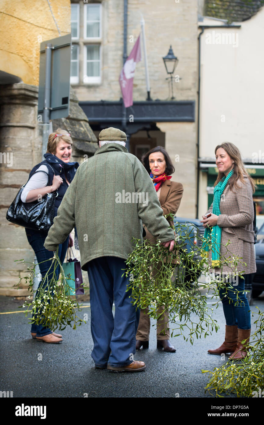 A man selling mistletoe at the market place at Christmas in Tetbury, Gloucestershire UK Dec 2013 Stock Photo