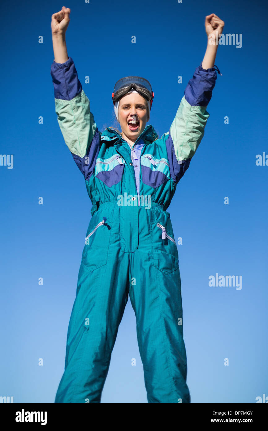 Woman wearing ski suit cheering Stock Photo