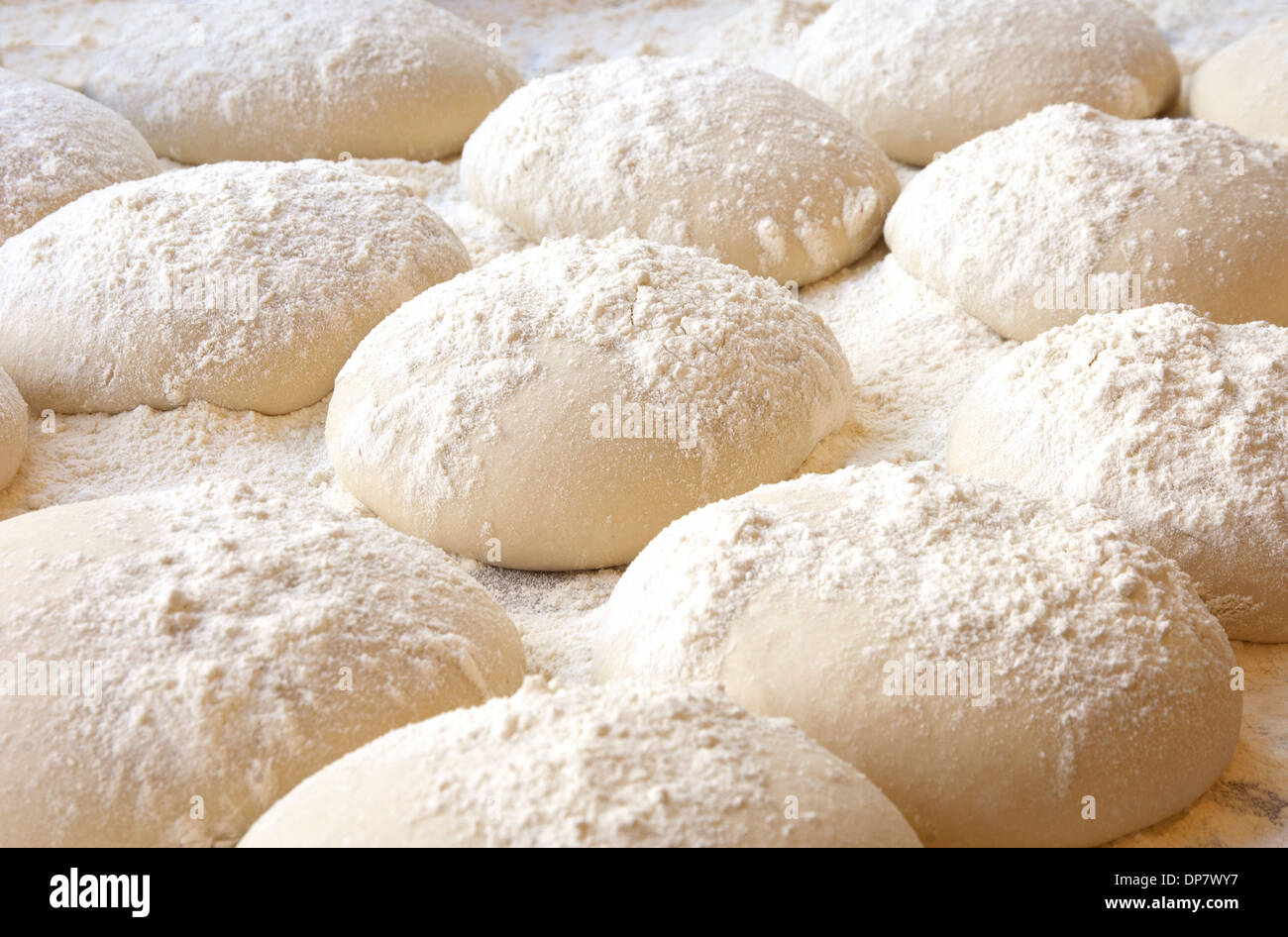 balls of dough covered with wheat flour ready for baking Stock Photo