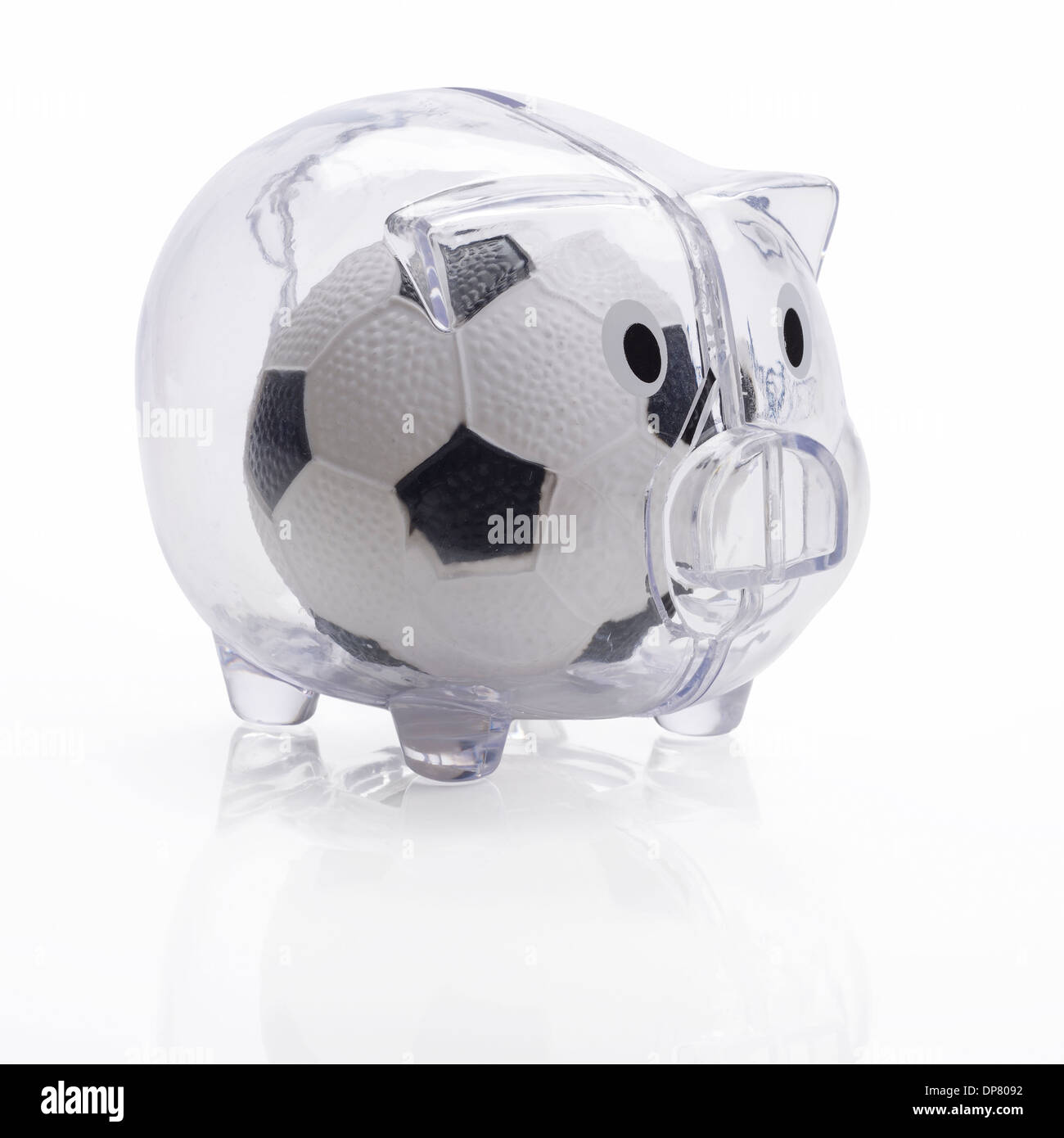 Football inside a plastic piggy bank Stock Photo