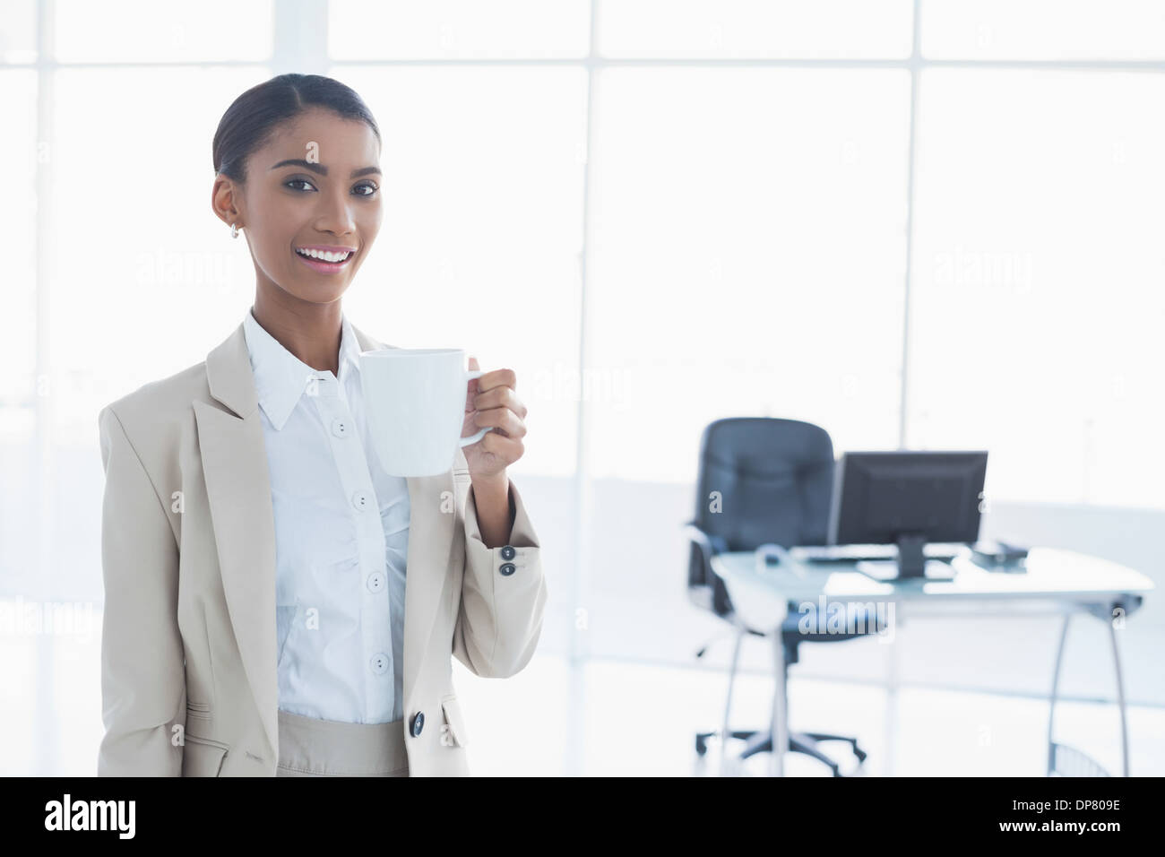 Smiling elegant businesswoman holding cup of coffee Stock Photo