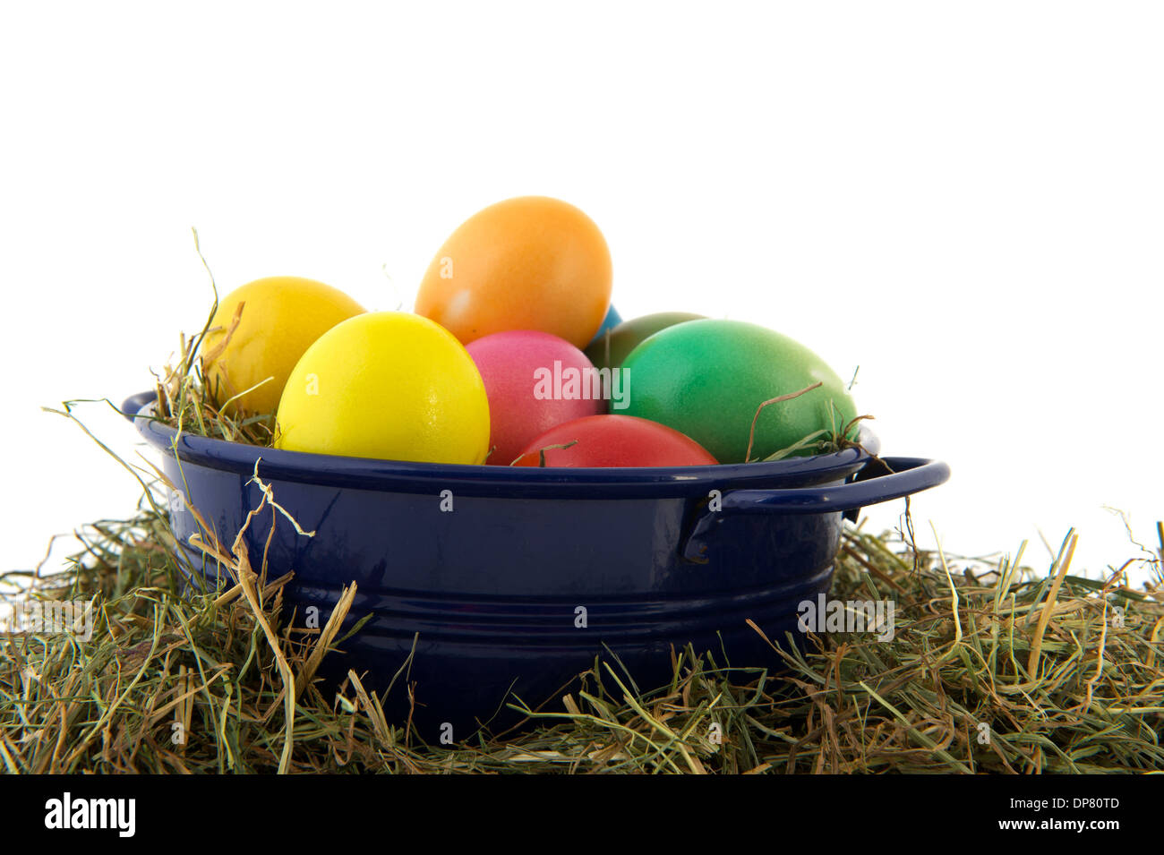Blue bucket with straw and colorful painted easter eggs Stock Photo