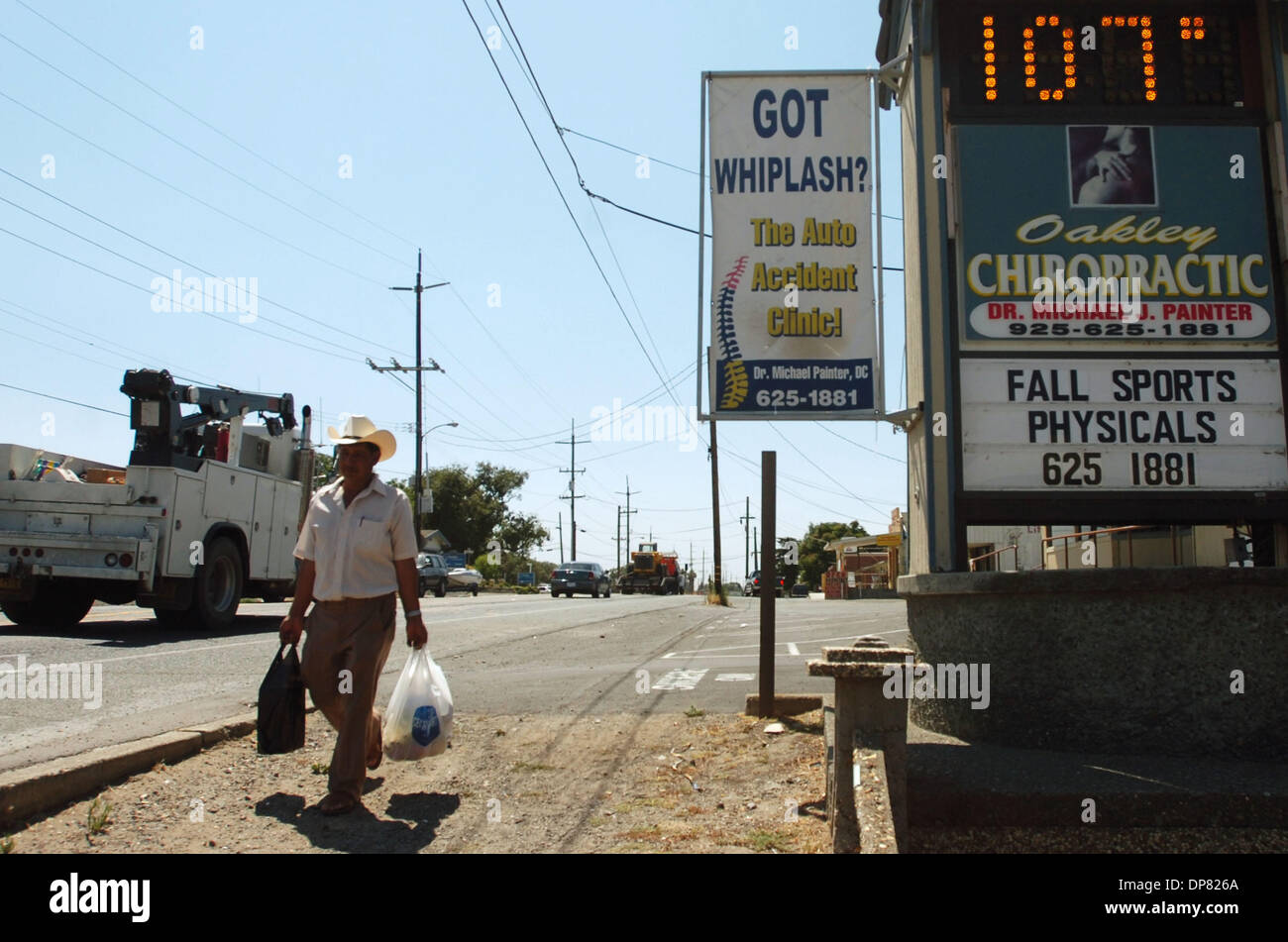 Jun 17, 2006 - Oakley, CA, USA - The electronic sign says it all as a  pedestrian carries his groceries along Main Street in Oakley, Calif.  Monday, July 17, 2006 Stock Photo - Alamy