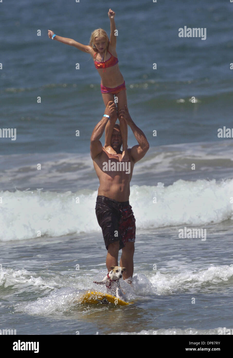 (Published 8/21/2006, B-8) August 20 ,2006 . Imperial Beach, California. ' ZOEY', a 2 and a half year old Jack Russell Terrier, looked like she was waving to the crowd as she surfed in along with his owner SCOTT CHANDLER. Atop SCOTT's shoulders was his daughter TYLER (7). TYLER has been surfing with her dad since she was 2 years old and ZOEY since the dog was 6 months old. This was Stock Photo