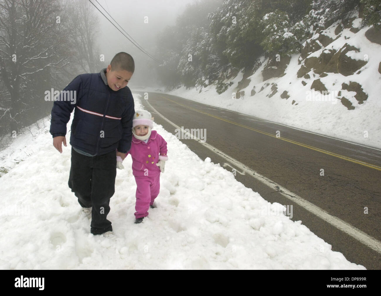 (PUBLISHED 04/16/2003; B-4:1,7; NC-1; NI-1) 11 year old ANTONIO HINOJOSA walks with little sister LETICIA, 2-1/2, along State Park Rd. on Palomar Mountain. They live in Valley Center and were there to see the snow with their parents. KEYWORDS: CHILDREN. SNOW. STORMS. U/T photo CHARLIE NEUMAN Stock Photo