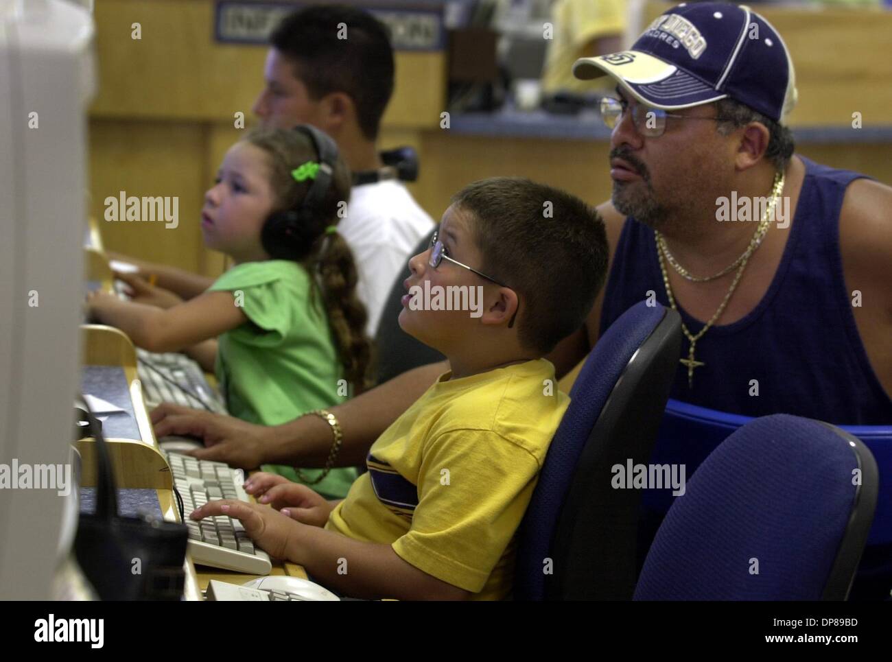 (Published 7/22/2004, B-2:2, UTS1820976) Javier Lopez, right, brought his three kids to the Lemon Grove Library for the morning so they could use the computers. Story is on the library's financial needs to move into a new building and acquire new books. The voters will decide whether to tax themselves or not to get it built. Peggy Peattie photo Stock Photo