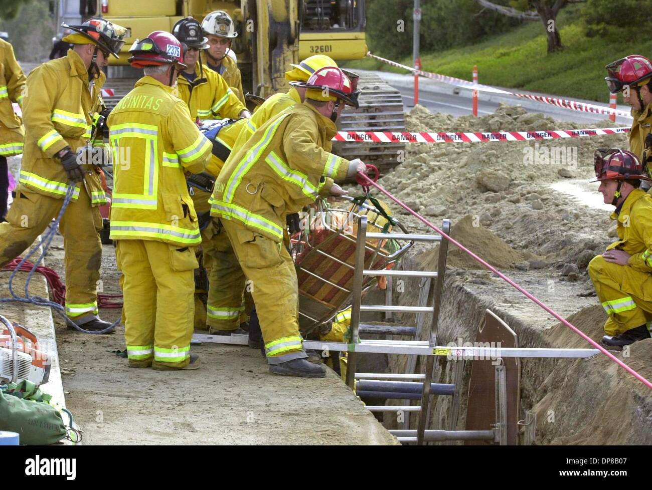 (Published on 11/24/2004, B-3:2,6, NI-3, NC-3) Emergency personnel pull a construction worker from a  deep trench he was trapped in near the median strip of Melrose Dr. near Alga Rd. in Carlsbad.  U/T photo CHARLIE NEUMAN Stock Photo