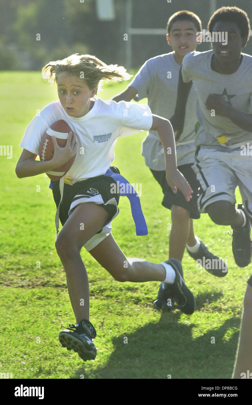 (published 11/13/2003, NC-7; NI-7) Natalie Gibney (member of the Eagles-7th and 8th graders flag football leaque) sprints past Daunte Turner (right)  and Tyler Downs(back of photo( from the Broncos team) for a long run at the youth flag football scrimmage at the Brengle Terrace Rec. Center in Vista.UT/DON KOHLBAUER Stock Photo