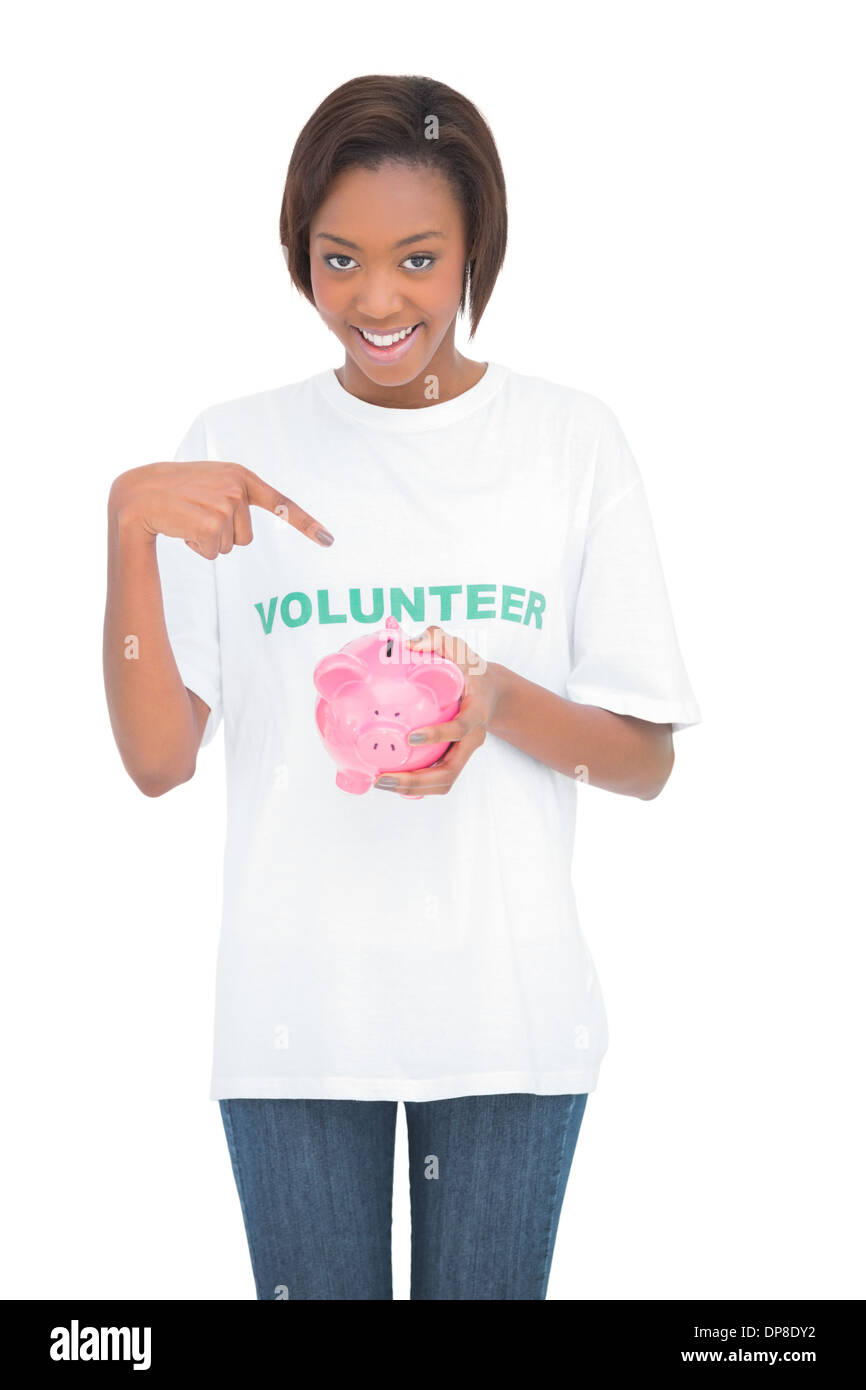 Smiling woman pointing at her piggy bank Stock Photo - Alamy