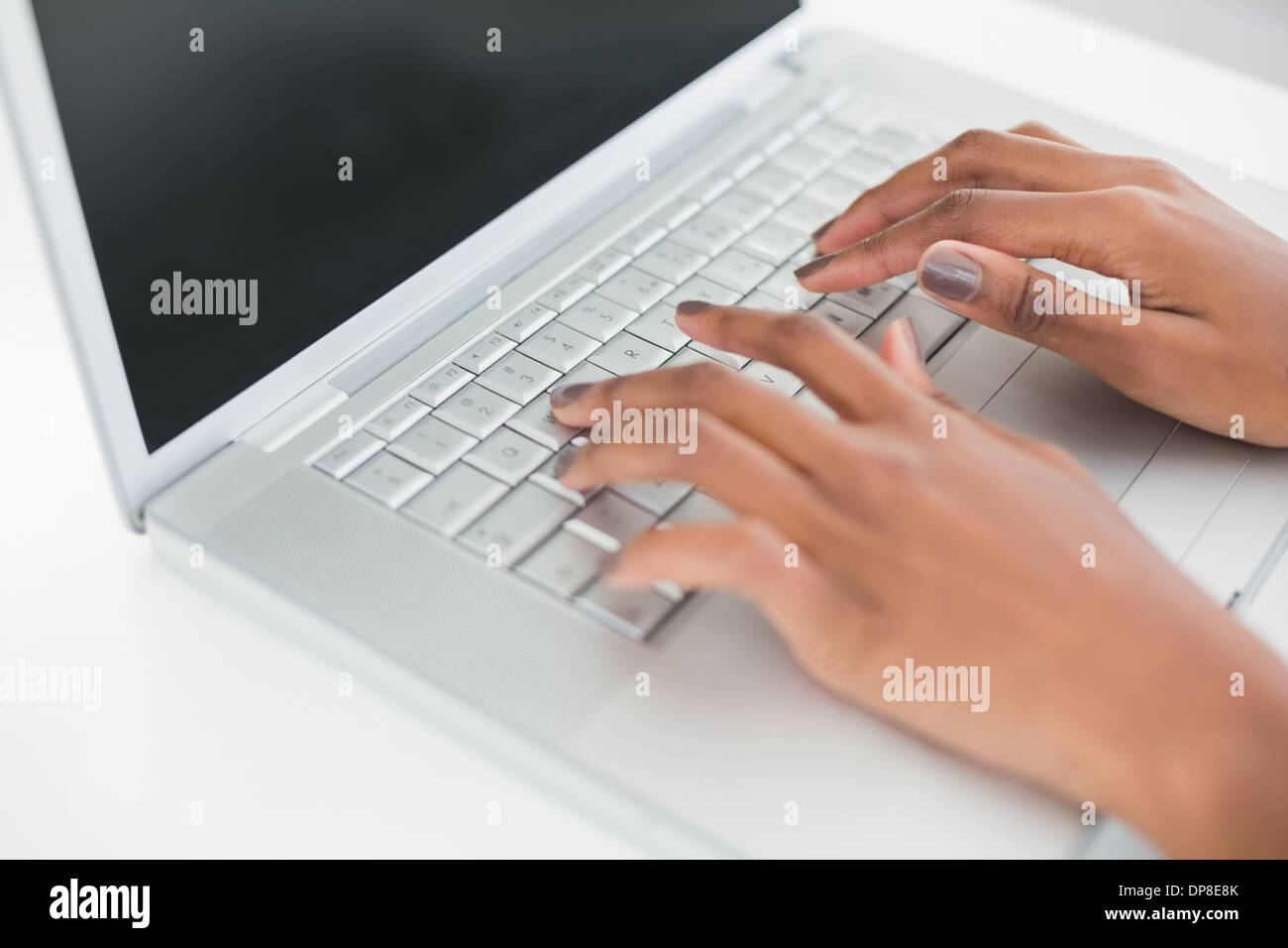 Close up on womans hands typing on her laptop Stock Photo