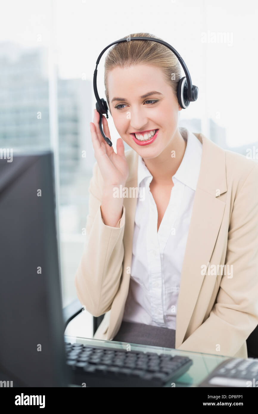 Smiling pretty agent wearing headset dealing with customer Stock Photo