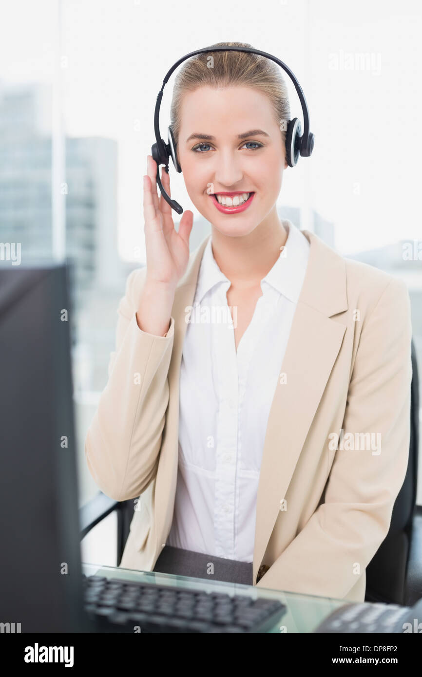 Cheerful pretty agent wearing headset dealing with customer Stock Photo